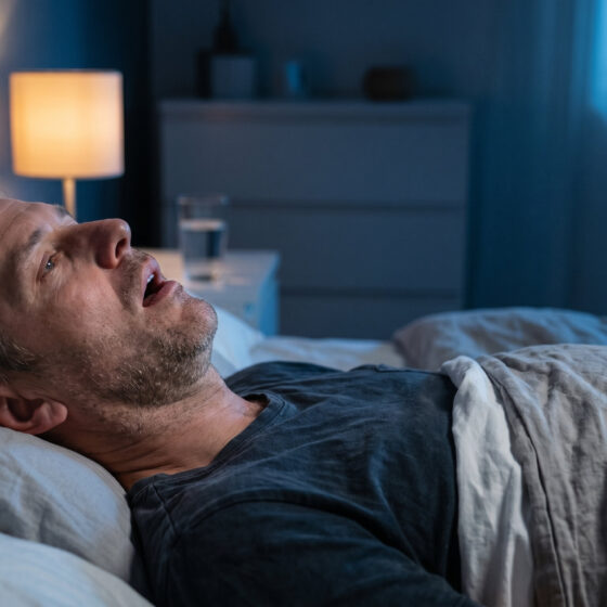 Uomo che dorme con sonno interrotto dalle apnee ostruttive del sonno