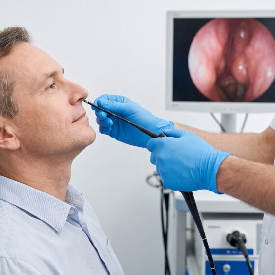 Specialista che introduce la sonda flessibile nel naso del paziente seduto durante la fibroscopia