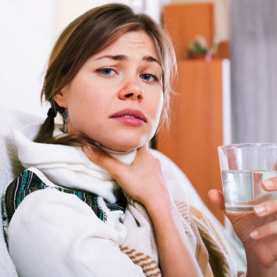 Donna con mal di gola e tonsille infiammate, sintomo della tonsillite